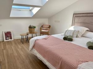 a bedroom with a large bed and a skylight at CARIATIDES SKY APARTMENT in Zamora