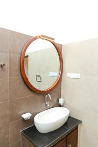 a bathroom with a white sink and a mirror at MILLET'S FOOD COMPANY AND COOKING CENTER in Negombo