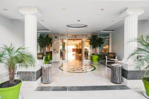 a lobby with potted plants in a building at SL La Perla Hotel Kemer in Antalya