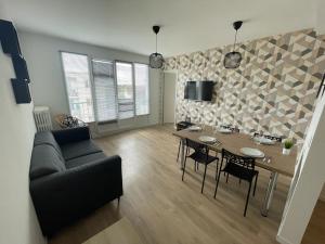 a living room with a table and a couch at Appt 4 chambres avec balcon, Spinelle in Ifs