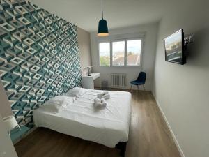 a bedroom with a bed with a teddy bear on it at Appt 4 chambres avec balcon, Spinelle in Ifs