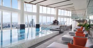 a swimming pool in a building with windows at The Ritz-Carlton Shanghai, Pudong in Shanghai
