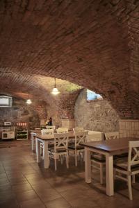 a dining room with tables and chairs and a brick wall at Agroturystyka u Świątków in Stara Kamienica