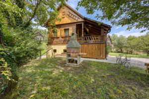 a log house with a bell in the yard at Holiday Home Carpe Diem in Jastrebarsko