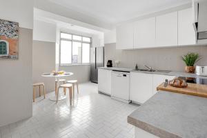 cocina con armarios blancos y mesa en Wonderful Shared Apartment in Alfornelos - NEAR METRO! en Lisboa