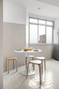 cocina con mesa, 2 taburetes y nevera en Wonderful Shared Apartment in Alfornelos - NEAR METRO! en Lisboa