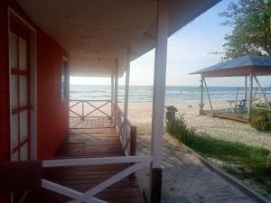 a porch of a house with a view of the beach at Tumombuvoi Homestay (Sidi place) in Tiga Papan