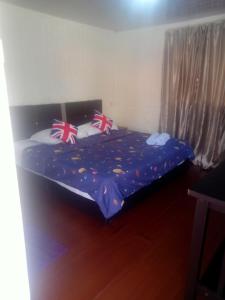 a bedroom with a bed with union jack pillows on it at Tumombuvoi Homestay (Sidi place) in Tiga Papan