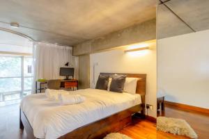 a bedroom with a large bed with white sheets at Incredible 2BD Loft by Regents Canal - Haggerston in London