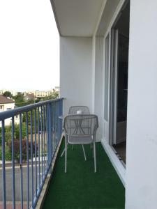 a chair sitting on a balcony with green carpet at Appt 4 chambres avec balcon, Spinelle in Ifs
