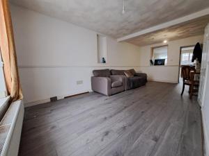 ein Wohnzimmer mit Sofa und Tisch in der Unterkunft Cheerful 2 bed house free parking nearby park in Aberdare