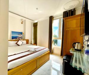 1 dormitorio con cama y mesa de cristal en Diamond Hotel, en Vung Tau