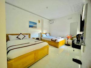 a hotel room with two beds and a television at Diamond Hotel in Vung Tau
