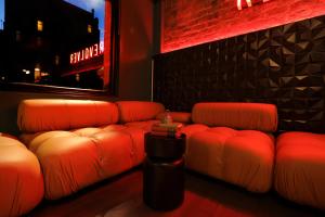 a room with red leather couches in a bar at Revolver in Glasgow