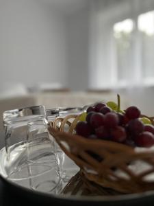 a bowl of grapes on a table with wine glasses at Apartament Pod Kamienną Górą II in Gdynia +8 photos