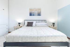1 dormitorio con 1 cama blanca y 2 mesitas de noche en Villa Porpora Luxury Design, en Módena