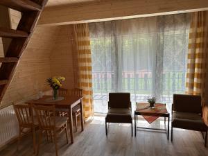 d'une salle à manger avec une table, des chaises et une fenêtre. dans l'établissement Hotel a Penzion PEGAS, à Vlachovice