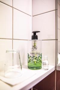 a bottle of green soap sitting on a bathroom counter at Hotel Kupolen in Borlänge