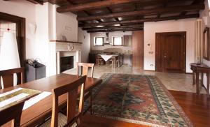 sala de estar con mesa, sillas y chimenea en Casa Vacanze Piantamori, en Cerreto di Spoleto