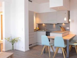 a kitchen with a wooden table and blue chairs at Ohlerich Speicher App_ 35 in Wismar