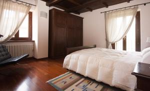 1 dormitorio con 1 cama, 1 silla y ventanas en Casa Vacanze Piantamori, en Cerreto di Spoleto