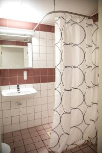 a bathroom with a shower and a sink at Hotel Kupolen in Borlänge