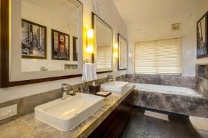 a bathroom with two sinks and a tub at ama Stays & Trails Helen's Garden , Bhopal in Bhopal