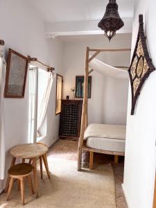 a bedroom with a bunk bed and a table and a chair at Riad Baladin in Essaouira