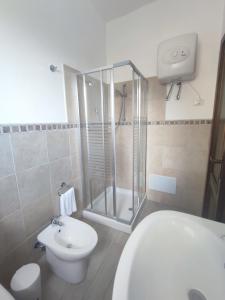 a bathroom with a shower and a toilet and a sink at San Raffaele Guest House in Villasimius