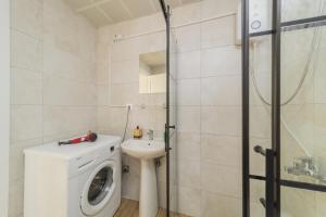 a bathroom with a washing machine and a sink at Luminous Flat w Shared Pool 5 min to Lara Beach in Antalya