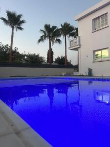a blue swimming pool in front of a house at Palm Villa in Kyrenia
