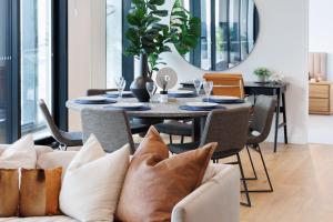 een eetkamer met een tafel en stoelen met kussens bij Luxurious 3 Bed Fortitude Valley Penthouse Retreat in Brisbane