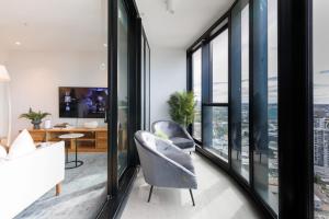 een woonkamer met glazen ramen en een stoel bij Luxurious 3 Bed Fortitude Valley Penthouse Retreat in Brisbane