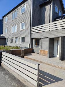 a house with a wooden fence in front of it at Apartament 1 Havoysund in Havøysund
