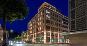 um edifício alto com um relógio em cima em PLAZA Premium Heidelberg em Heidelberg