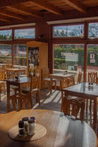 un restaurante con mesas, sillas y ventanas en Oaza Ricany en Ricany