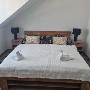ein Schlafzimmer mit einem Bett mit zwei Schwänen darauf in der Unterkunft Černá růže - Apartmán 6 in Pilsen