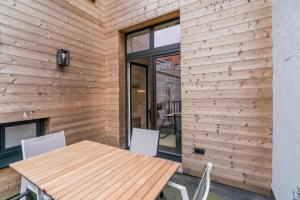 a wooden patio with a wooden table and chairs at Maison les Bruyères in Blankenberge