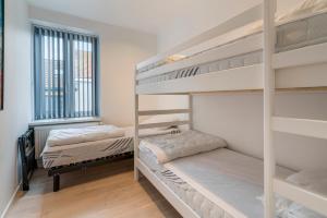 two bunk beds in a room with a window at Maison les Bruyères in Blankenberge