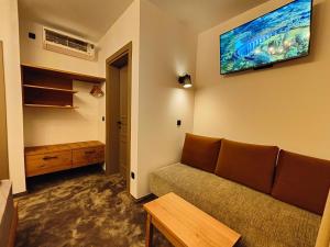 uma sala de estar com um sofá e uma televisão na parede em Pula Residence Rooms and Apartments Old City Center em Pula