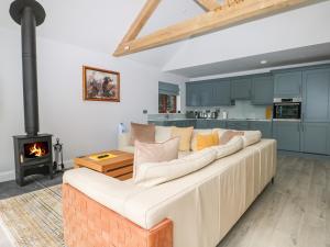 uma sala de estar com um sofá branco e um fogão em Lapwings em Fareham