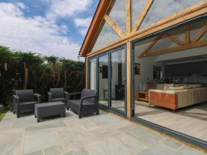 a patio with chairs and a couch and windows at Lapwings in Fareham