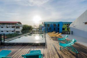 a deck with chairs and a swimming pool on a building at Lek Lek Samui Room X Coffee Bar in Chaweng