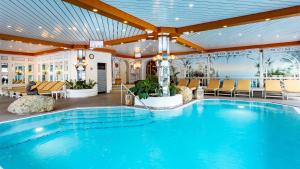 a large swimming pool in a hotel lobby at Alpenhotel Oberstdorf - ein Rovell Hotel in Oberstdorf