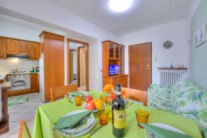 ein Esszimmer mit einem Tisch und einer Flasche Wein in der Unterkunft Leonardo House Garden Stresa Center - Happy Rentals in Stresa