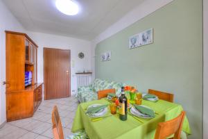 ein Wohnzimmer mit einem Tisch und einem grünen Tischtuch in der Unterkunft Leonardo House Garden Stresa Center - Happy Rentals in Stresa