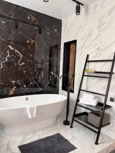 a bathroom with a white tub and a marble wall at Number 21 by DBI in Kyiv