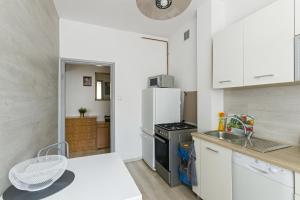 una cucina con armadietti bianchi e frigorifero bianco di Apartament 2 pokojowy Gdańsk a Danzica