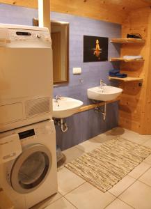 a bathroom with a washing machine and a sink at Ferienwohnung Handweberei Huber in Saaldorf-Surheim