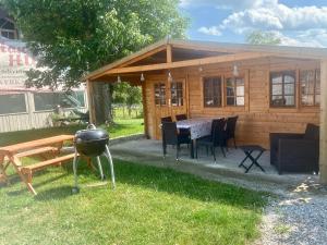 a cabin with a grill and a table and chairs at Ferienwohnung Handweberei Huber in Saaldorf-Surheim